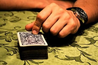 jeu de carte avec une main désignant le paquet
